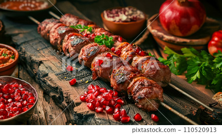 Georgian Mtsvadi kebab with ripe broken pomegranate grains and appetizer Pkhali and Badrijani lie on an old wooden table in a tavern, lunch and idea for a menu in a traditional cafe Georgian Mtsvadi kebab with ripe broken pomegranate grains and appetizer Pkhali and Badrijani lie on an old wooden table in a tavern, lunch and idea for a menu in a traditional cafe 110520913