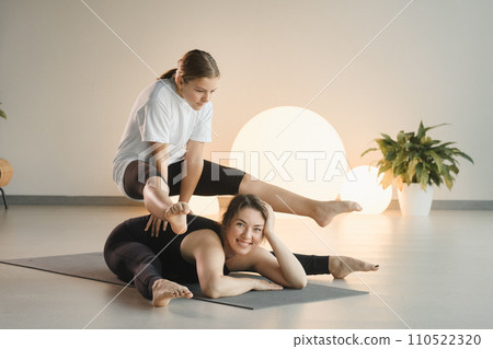 Mom and teenage daughter do gymnastics together in the fitness room. A woman and a girl train in the gym Mom and teenage daughter do gymnastics together in the fitness room. A woman and a girl train in the gym 110522320