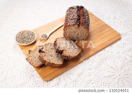 Fresh baked loaf of spelt sourdough bread with hemp seeds is on linen towel. Healthy pastry Fresh baked loaf of spelt sourdough bread with hemp seeds is on linen towel. Healthy pastry 110524051