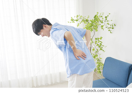 A man with back pain at home A man with back pain at home 110524523
