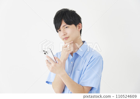 A man holding a smartphone while thinking, white background A man holding a smartphone while thinking, white background 110524609