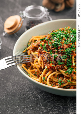 Eating spaghetti bolognese with herbs 110524799