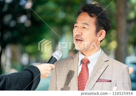 A man responding to an interview on the street A man responding to an interview on the street 110525954