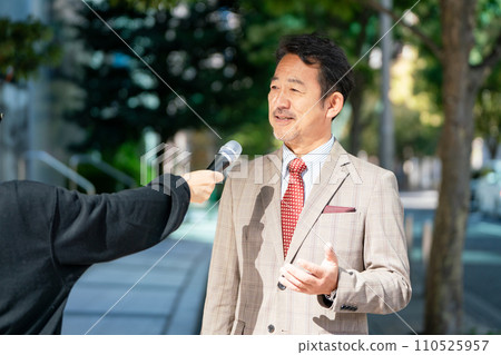 A man responding to an interview on the street A man responding to an interview on the street 110525957
