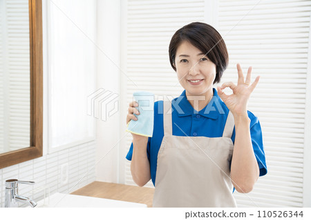 House cleaning woman with blue towel in washroom House cleaning woman with blue towel in washroom 110526344