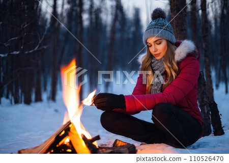 young traveler hiker women hands warm by the fire. She sit near the flame. Caucasian woman warms hands near small bonfire at winter wilderness evening. Travel, Survival, lifestyle concept.. AI young traveler hiker women hands warm by the fire. She sit near the flame. Caucasian woman warms hands near small bonfire at winter wilderness evening. Travel, Survival, lifestyle concept.. AI 110526470