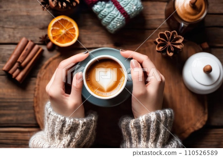 Woman holding cup of hot coffee on rustic wooden table, closeup photo of hands in warm sweater with mug, winter morning concept, top view. AI Woman holding cup of hot coffee on rustic wooden table, closeup photo of hands in warm sweater with mug, winter morning concept, top view. AI 110526589