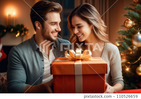 Emotional happy young woman feeling excited of getting wished Christmas gift in wrapped box from caring smiling husband, spending time near decorated tree in stylish house, new year celebration.. AI Emotional happy young woman feeling excited of getting wished Christmas gift in wrapped box from caring smiling husband, spending time near decorated tree in stylish house, new year celebration.. AI 110526659