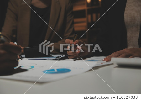 Financial analysts analyze business financial reports on a digital tablet planning investment project during a discussion at a meeting of corporate showing the results of their successful teamwork. 110527038