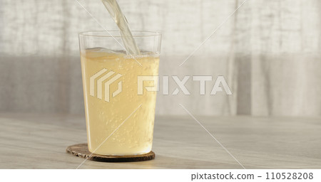 closeup pour ginger beer in a tumbler glass on oak table with copy space closeup pour ginger beer in a tumbler glass on oak table with copy space 110528208