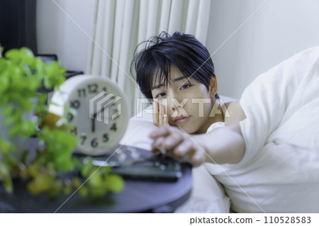 年輕女子早上起床，試圖停止鬧鐘 110528583