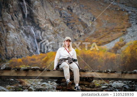 Moment of solitude, girl on the bridge by the waterfall in the mountains Moment of solitude, girl on the bridge by the waterfall in the mountains 110528930