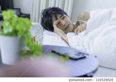 Young woman waking up in bed in the morning Young woman waking up in bed in the morning 110529026