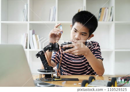Asian teenager doing robot project in science classroom. technology of robotics programing and STEM education concept. 110529325