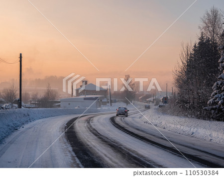 Frosty morning sunrise winter snow-covered highway through Cherdyn village covered with snow. 110530384
