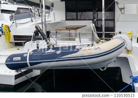 Inflatable tender motor boat on swim platform of superyacht. Inflatable dinghy with outboard engine. Power boat. Inflatable tender motor boat on swim platform of superyacht. Inflatable dinghy with outboard engine. Power boat. 110530515