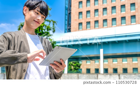 Looking up at a young office casual businessman with a tablet 110530728