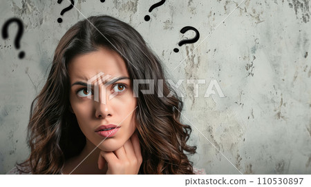 Portrait of a woman with perplexed facial expression; some black question marks above her head Portrait of a woman with perplexed facial expression; some black question marks above her head 110530897