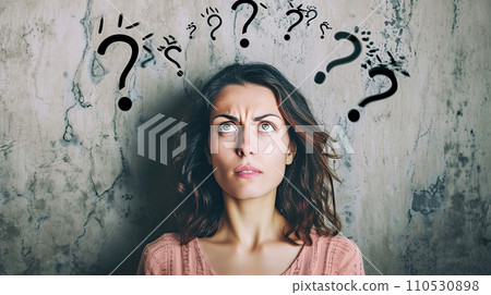 Portrait of a woman with perplexed facial expression; some black question marks above her head 110530898