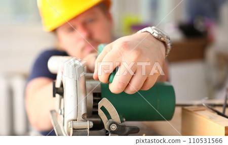 Arms of worker using electric saw closeup 110531566