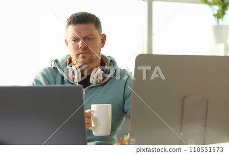 Handsome smiling male student using online 110531573
