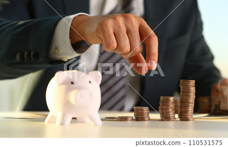 Hand businessman putting pin money into pig 110531575