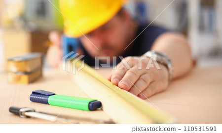 Arms of worker measuring wooden bar closeup Arms of worker measuring wooden bar closeup 110531591