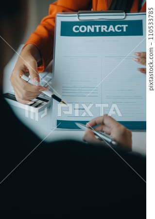 Closeup asian male people car salesman or sales manager offers to sell a car and explains and reads the terms of signing a car contract and insurance. 110533785