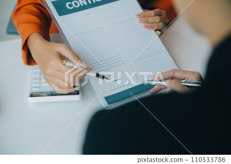 Closeup asian male people car salesman or sales manager offers to sell a car and explains and reads the terms of signing a car contract and insurance. 110533786