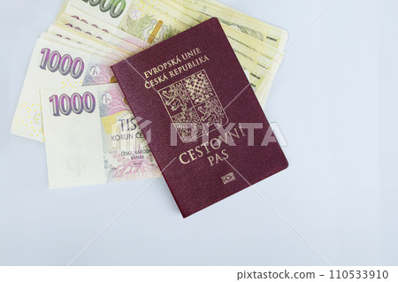 Czech Republic passport are stacked various denominations CZK koruna banknotes cash stacked on white background 110533910