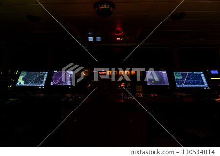Navigational bridge on big cargo ship. Wheelhouse on vessel. ECDIS, radar. Night time. Navigational bridge on big cargo ship. Wheelhouse on vessel. ECDIS, radar. Night time. 110534014