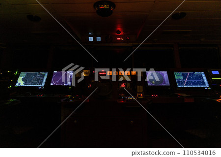 Navigational bridge on big cargo ship. Wheelhouse on vessel. ECDIS, radar. Night time. Navigational bridge on big cargo ship. Wheelhouse on vessel. ECDIS, radar. Night time. 110534016