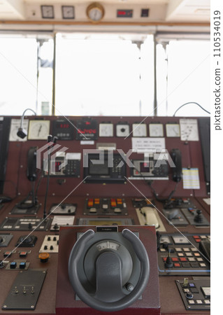 Ship's control device. Engine control from navigational bridge. Focused on helm, blured background. Ship's control device. Engine control from navigational bridge. Focused on helm, blured background. 110534019
