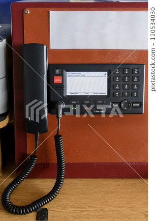 Navigational control panel and VHF radio with hand. Radio communication at sea. Working on the ship's bridge. Navigational control panel and VHF radio with hand. Radio communication at sea. Working on the ship's bridge. 110534030