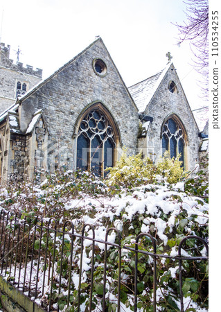 Historic stone church covered in snow, cityscape on the outskirts of London 110534255