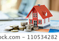 House and stack of coins with white background. Home savings concept. Energy saving. Cost of the house. Cost of living. Savings for home goal. Dreaming of home. 110534282