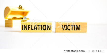 Inflation victim symbol. Concept words Inflation victim on wooden block. Beautiful white table white background. Beautiful wooden chest with coins. Business inflation victim concept. Copy space. 110534413