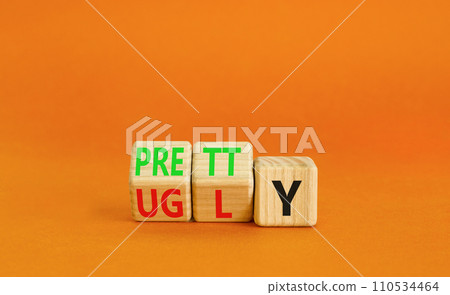 Pretty or ugly symbol. Concept word Pretty or Ugly on wooden cubes. Beautiful orange table orange background. Business lifestyle and pretty or ugly concept. Copy space. Pretty or ugly symbol. Concept word Pretty or Ugly on wooden cubes. Beautiful orange table orange background. Business lifestyle and pretty or ugly concept. Copy space. 110534464