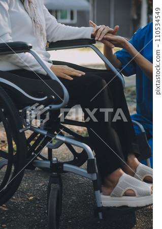 A nurse take care a senior male on wheelchair in his garden at home 110534549