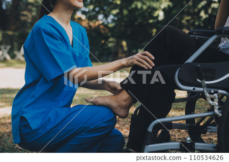 young asian physical therapist working with senior woman on walking with a walker 110534626