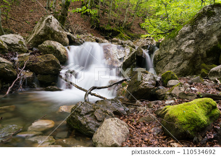 The stream of water in the river flowing between the rocks The stream of water in the river flowing between the rocks 110534692