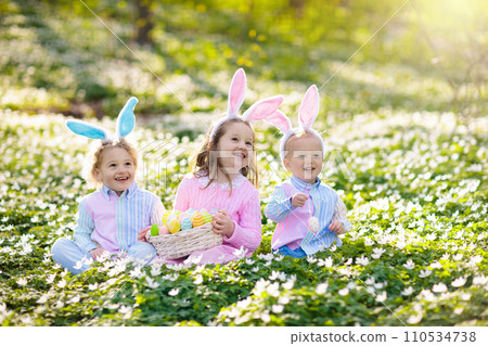 Kids with bunny ears on Easter egg hunt. Kids with bunny ears on Easter egg hunt. 110534738