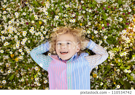 Child on green grass lawn with summer flowers 110534742