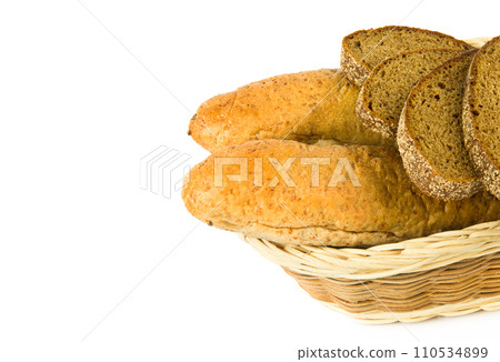 Bread and baguettes in a wicker basket isolated on a white. Free space for text. 110534899