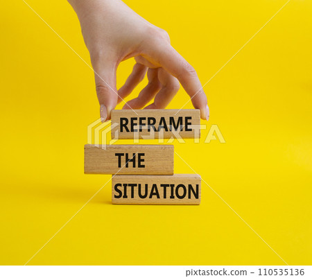Reframe the situation symbol. Concept words Reframe the situation on wooden blocks. Beautiful yellow background. Businessman hand. Business concept. Copy space. 110535136