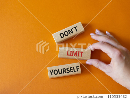 Do not limit yourself symbol. Concept words Do not limit yourself on wooden blocks. Businessman hand. Beautiful orange background. Business and Do not limit yourself concept. Copy space Do not limit yourself symbol. Concept words Do not limit yourself on wooden blocks. Businessman hand. Beautiful orange background. Business and Do not limit yourself concept. Copy space 110535482