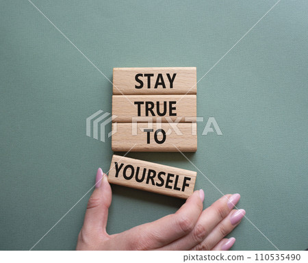 Stay True to Yourself symbol. Wooden blocks with words Stay True to Yourself. Businessman hand. Beautiful grey green background. Business and Stay True to Yourself concept. Copy space. Stay True to Yourself symbol. Wooden blocks with words Stay True to Yourself. Businessman hand. Beautiful grey green background. Business and Stay True to Yourself concept. Copy space. 110535490
