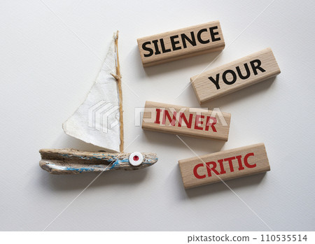 Silence your inner critic symbol. Wooden blocks with words Silence your inner critic. Beautiful white background with boat. Business and Silence your inner critic concept. Copy space 110535514
