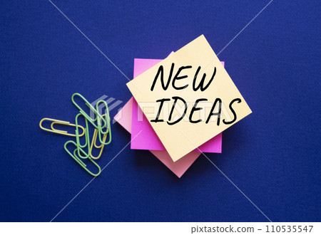 New ideas symbol. Orange steaky note with concept words New Ideas. Beautiful deep blue background. Business and New ideas concept. Copy space New ideas symbol. Orange steaky note with concept words New Ideas. Beautiful deep blue background. Business and New ideas concept. Copy space 110535547