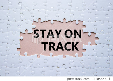 Stay on track symbol. Concept words Stay on track on white puzzle. Beautiful pink background. Business and Stay on track concept. Copy space. Stay on track symbol. Concept words Stay on track on white puzzle. Beautiful pink background. Business and Stay on track concept. Copy space. 110535601